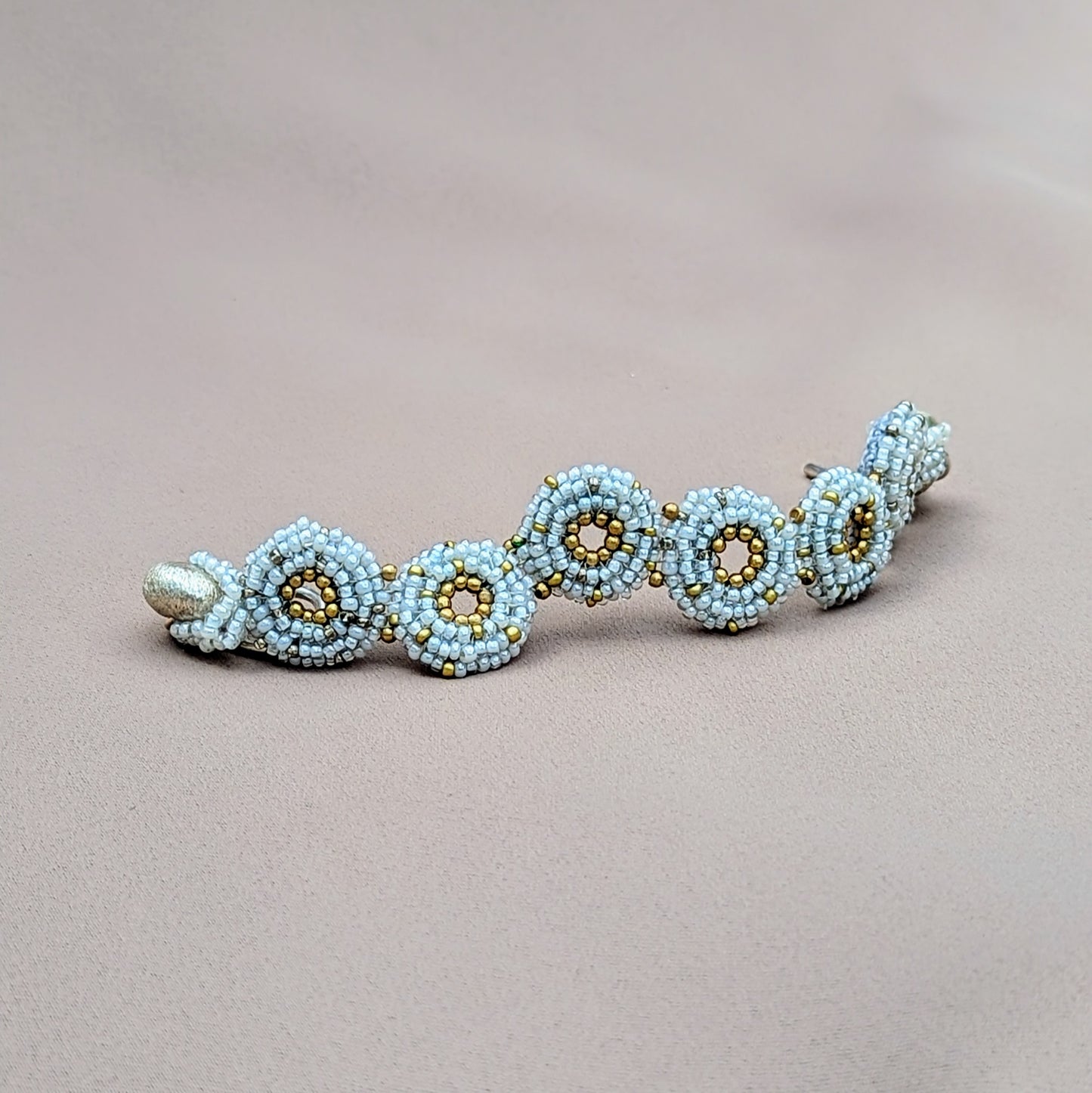 Close-up of beaded winter bracelet with intricate seed beadwork and silver toggle clasp.