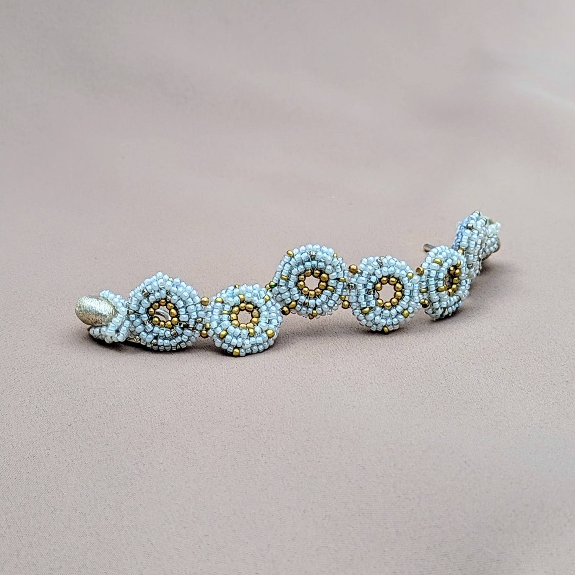 Close-up of beaded winter bracelet with intricate seed beadwork and silver toggle clasp.