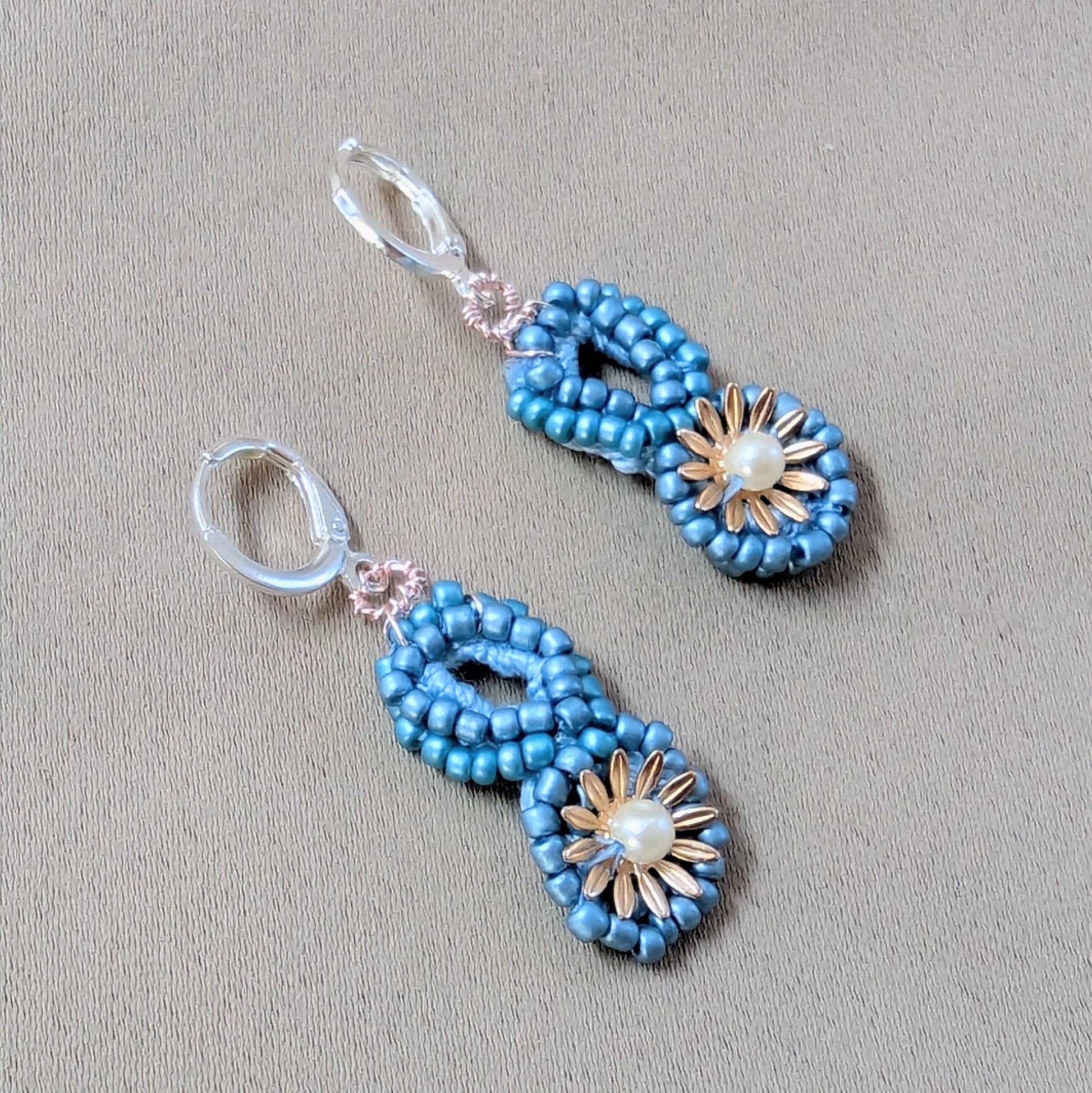 Tara earrings illuminated under soft light capturing rose gold wire and pearl accents.