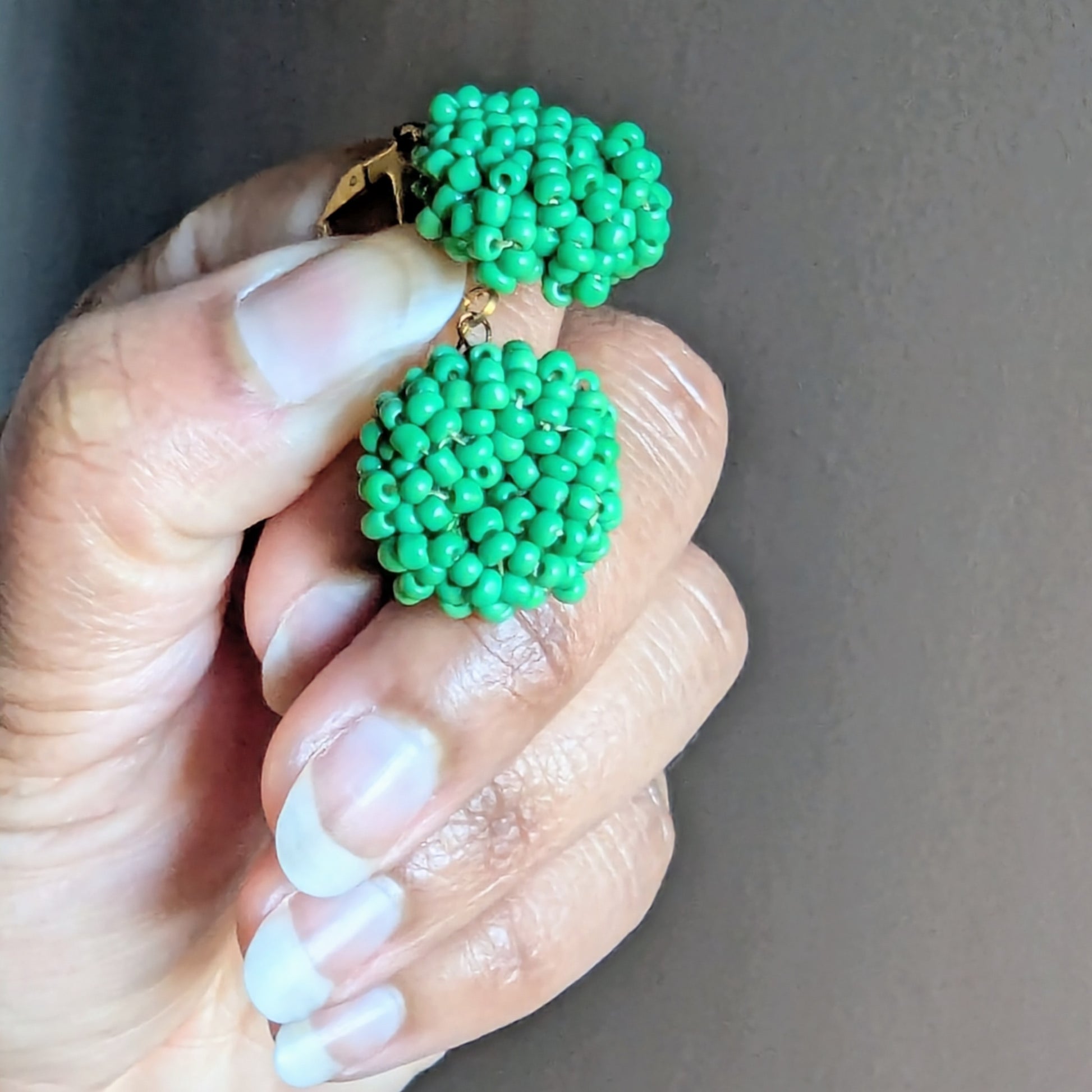 Close-up of Masi Harita earrings highlighting the intricate green Czech glass beadwork and the soft sheen of Egyptian cotton thread, reflecting artisanal craftsmanship and eco-conscious design.