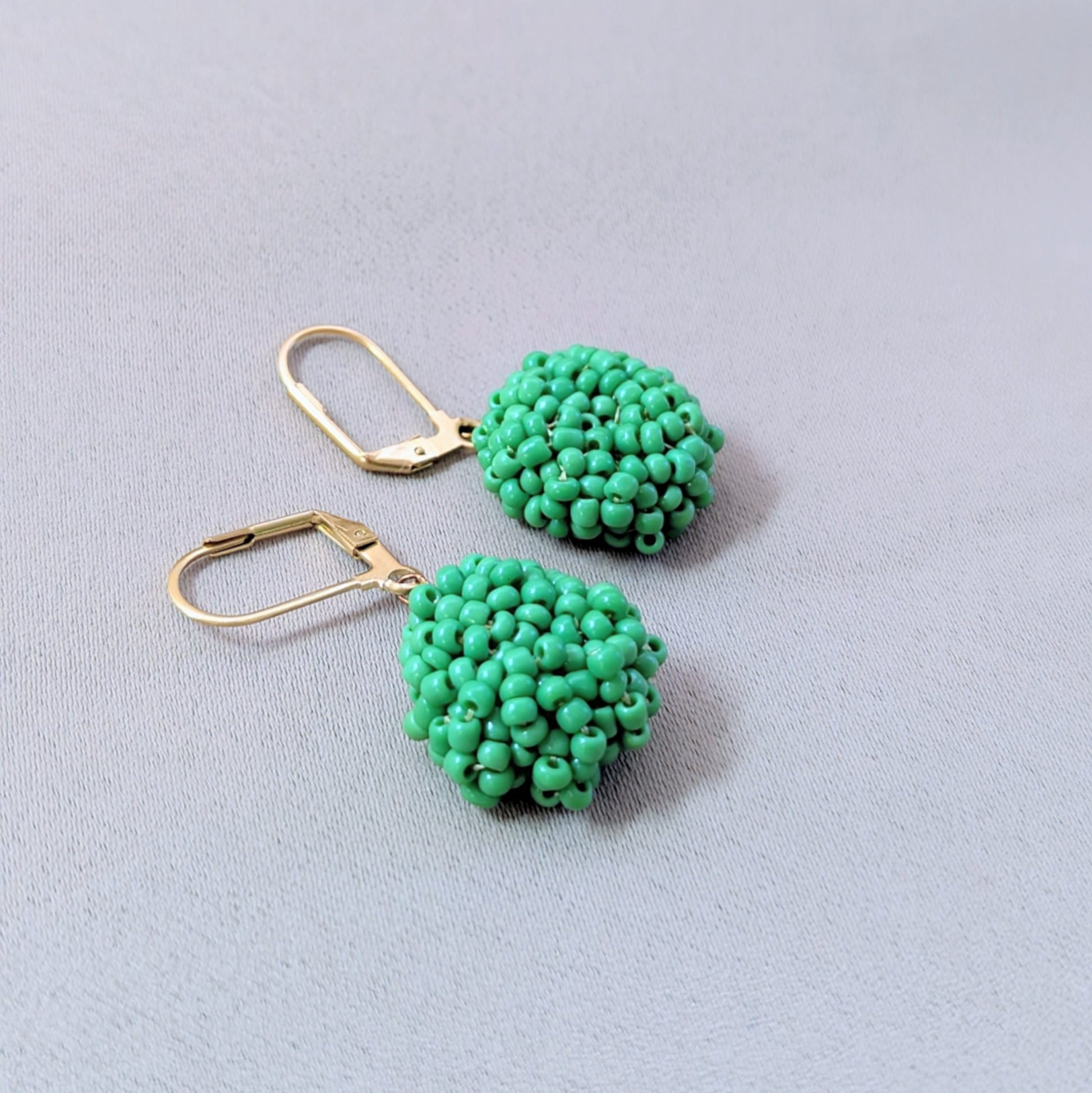 Handcrafted green beaded earrings from Mayaani Jewellery’s Everyday Edit featuring gold lever-back clasps and antique bronze wire — lightweight, elegant, and sustainable.