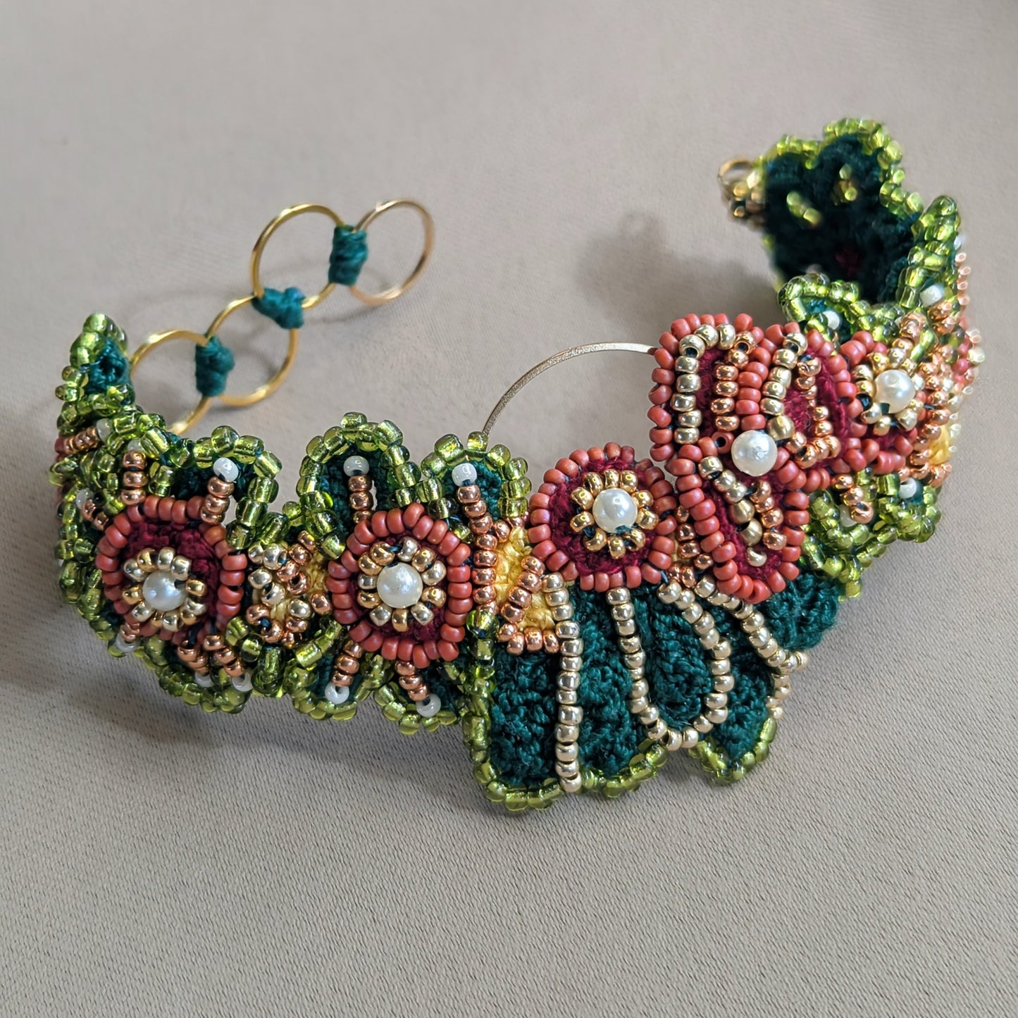 Detailed floral inspired designer bracelet by Mayaani Jewellery - handcrafted in teals, coral, reds, greens and gold for jewellery reflective of diaspora women.