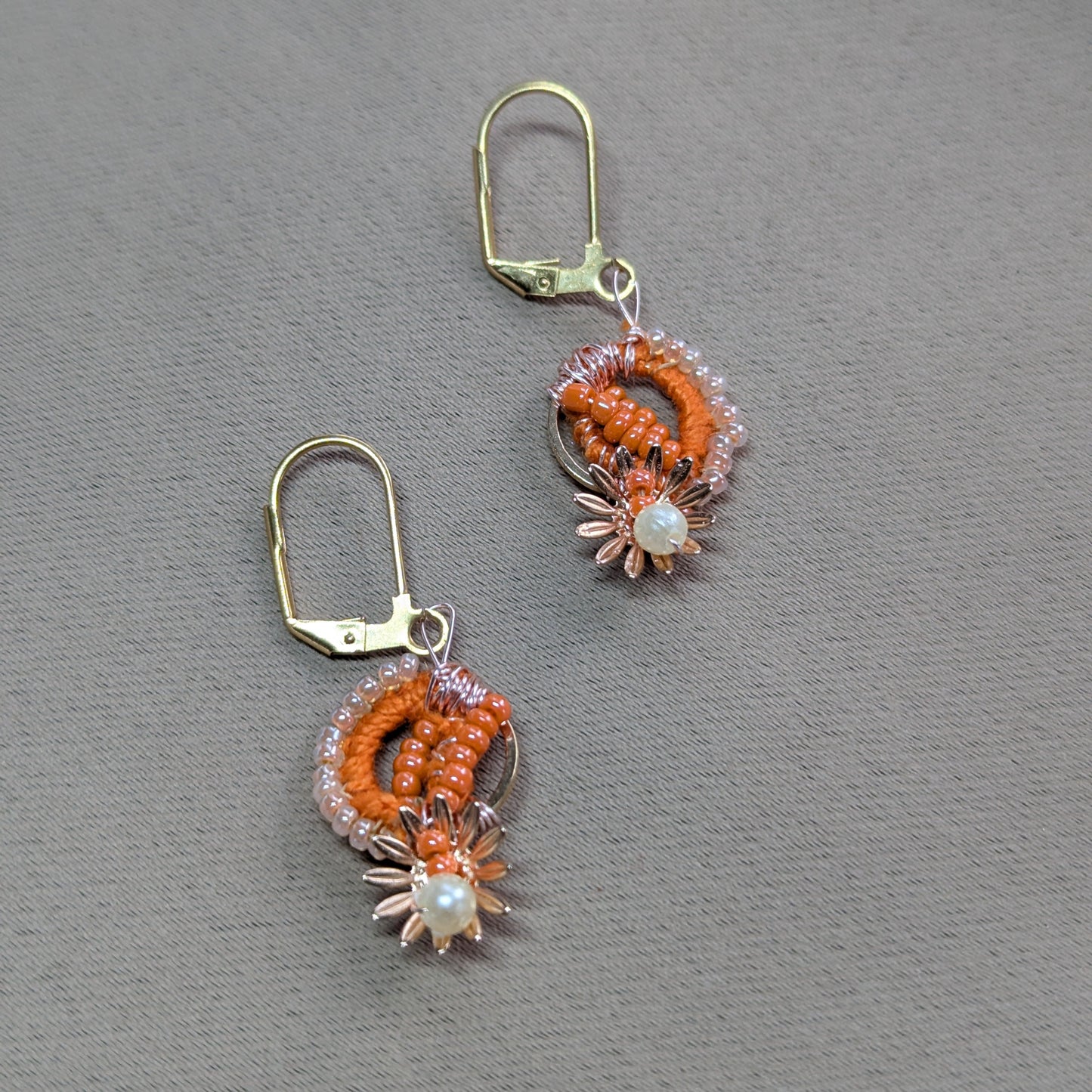 Close-up of Suhasani earrings featuring Miyuki beads, seed pearls, and gold floral accents.