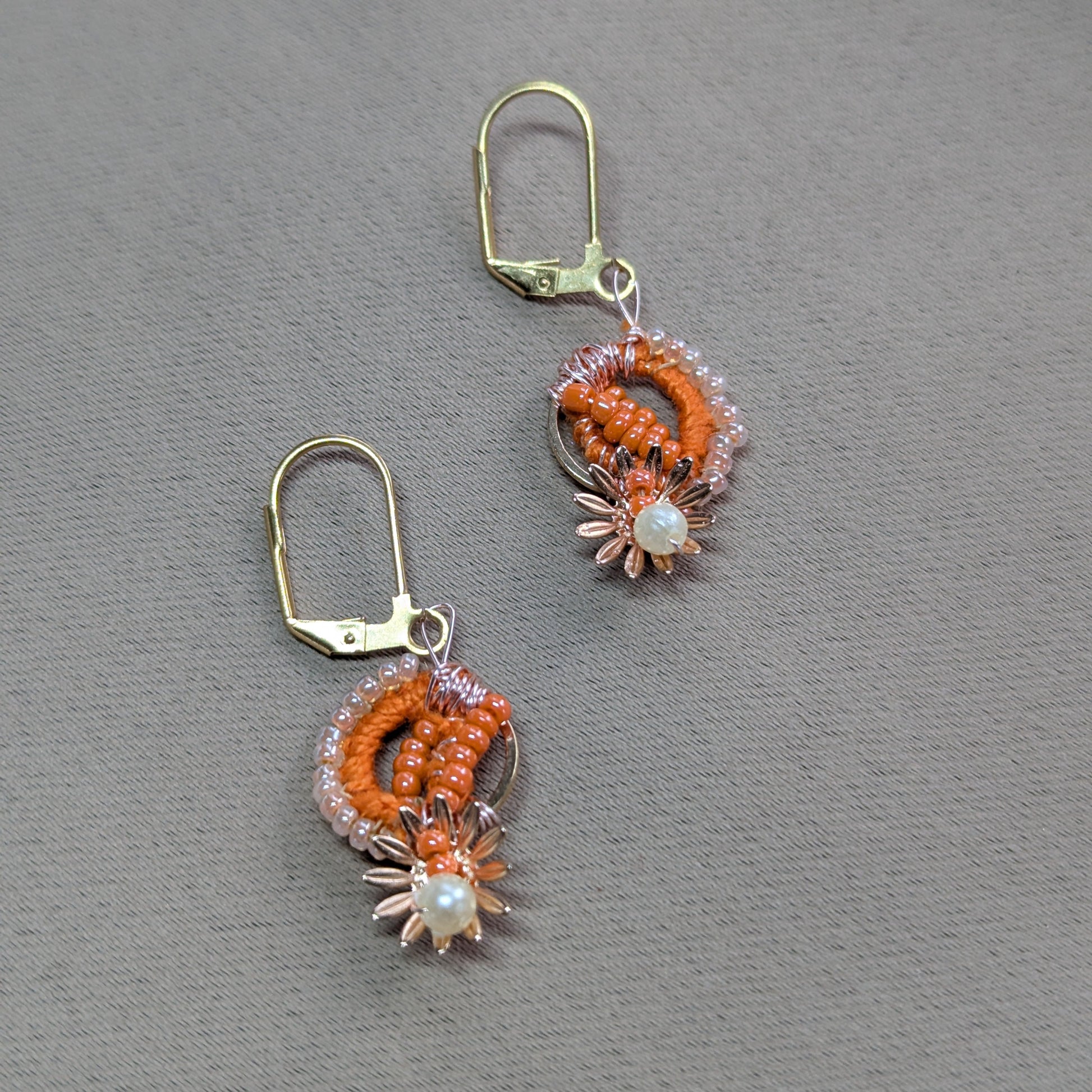 Close-up of Suhasani earrings featuring Miyuki beads, seed pearls, and gold floral accents.