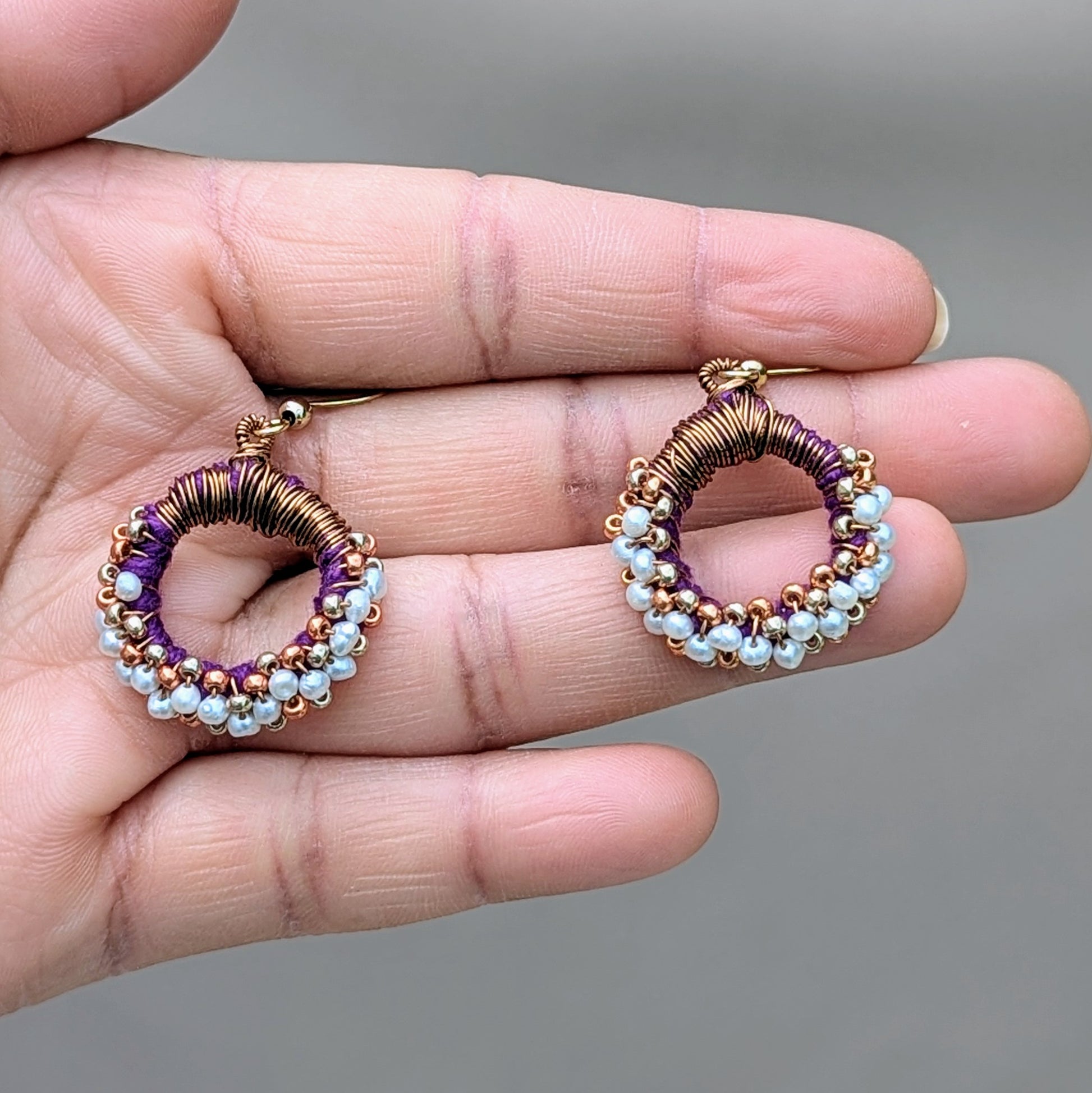 Elegant freshwater pearl earrings with purple and copper beadwork, handmade in the UK.