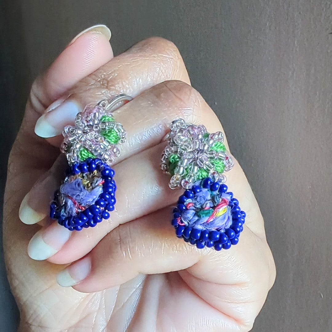 Gaia earrings photographed held gently in a hand capturing Earth-inspired artistry and slow-made craftsmanship.