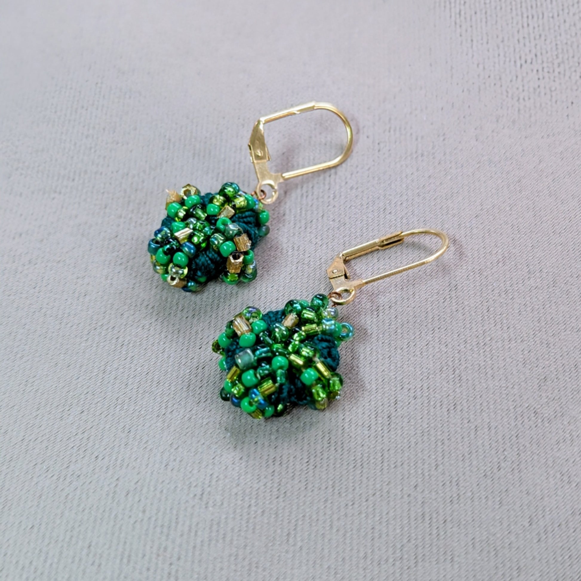 An everyday pair of luxurious beaded green and gold earrings.