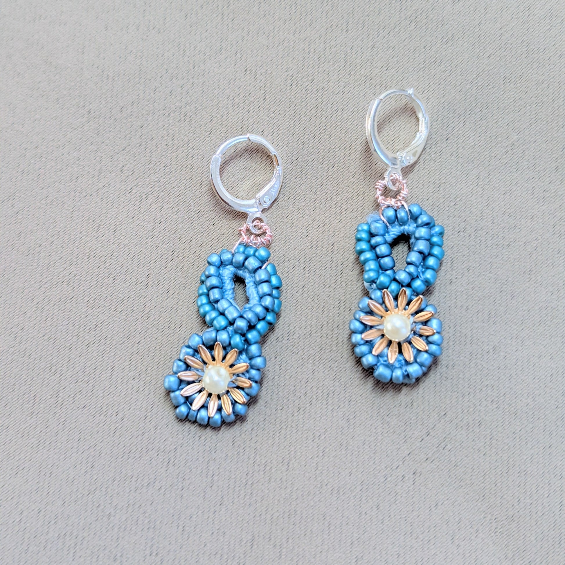 Blue and gold beaded earrings symbolising starlight and renewal, handcrafted with sustainable artistry.