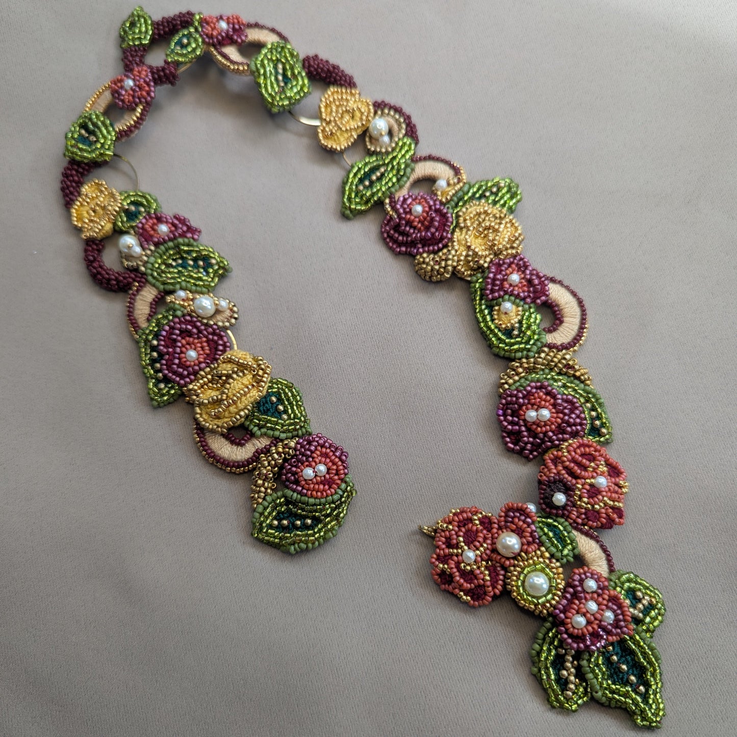 Colourful red, green, gold and yellow Rukmini designer necklace by Mayaani Jewellery UK featuring a front facing detachable pendant clasp.