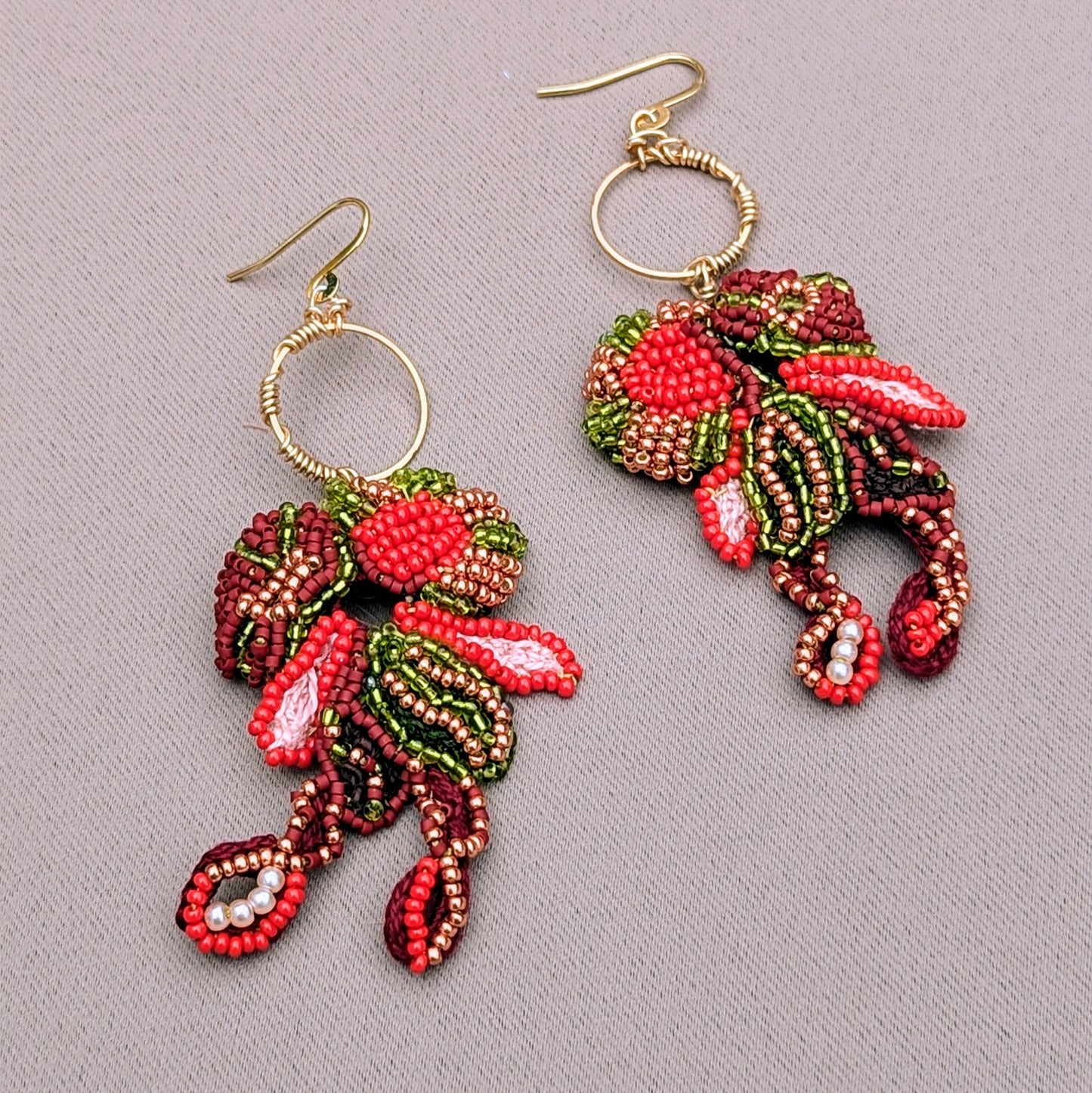 Artisan beaded Indian earrings with gold hoops, featuring abstract floral forms and flowing movement.