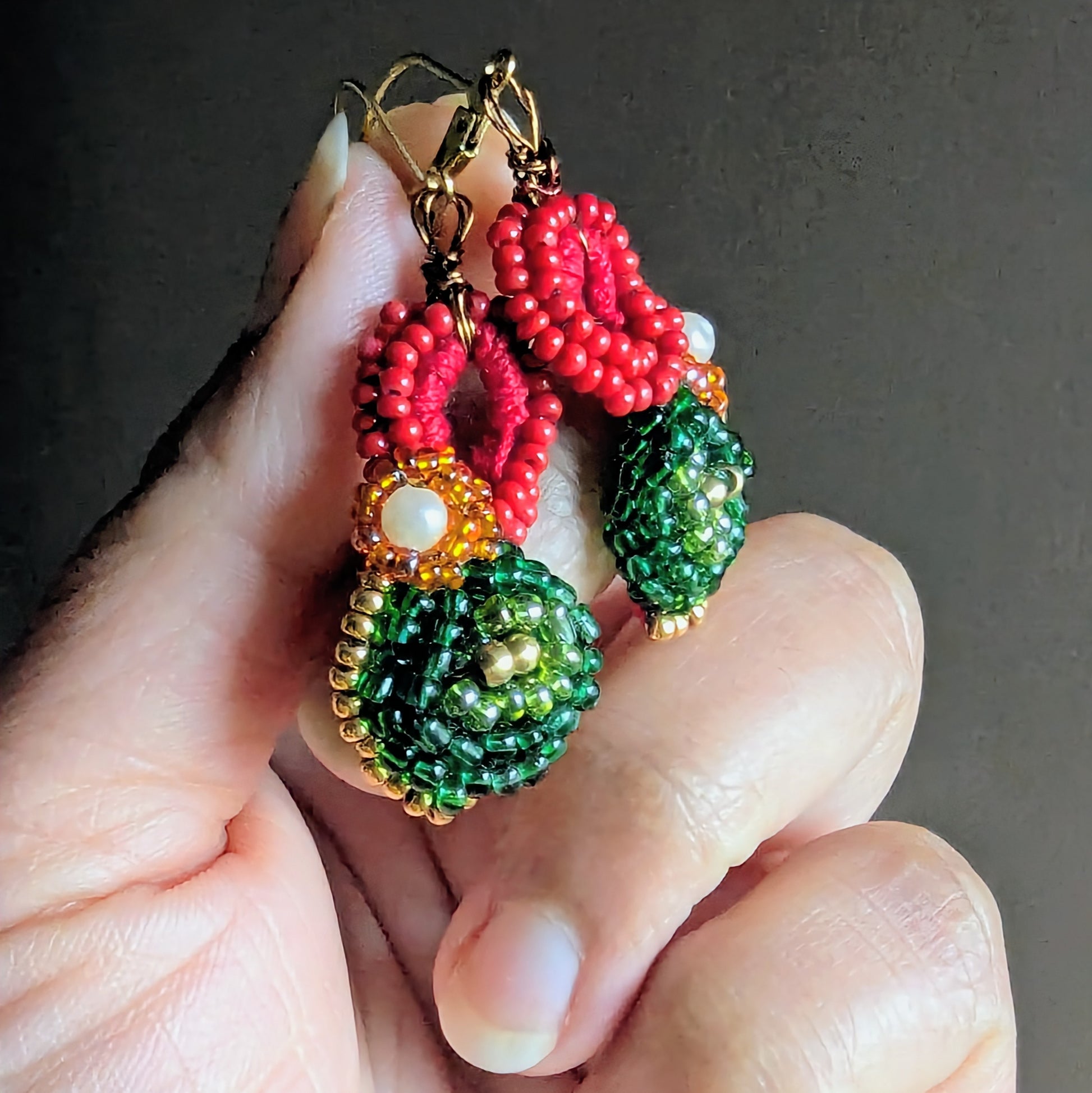 Close up of Vasanta beaded earrings highlighting pearl centre and brass detail.