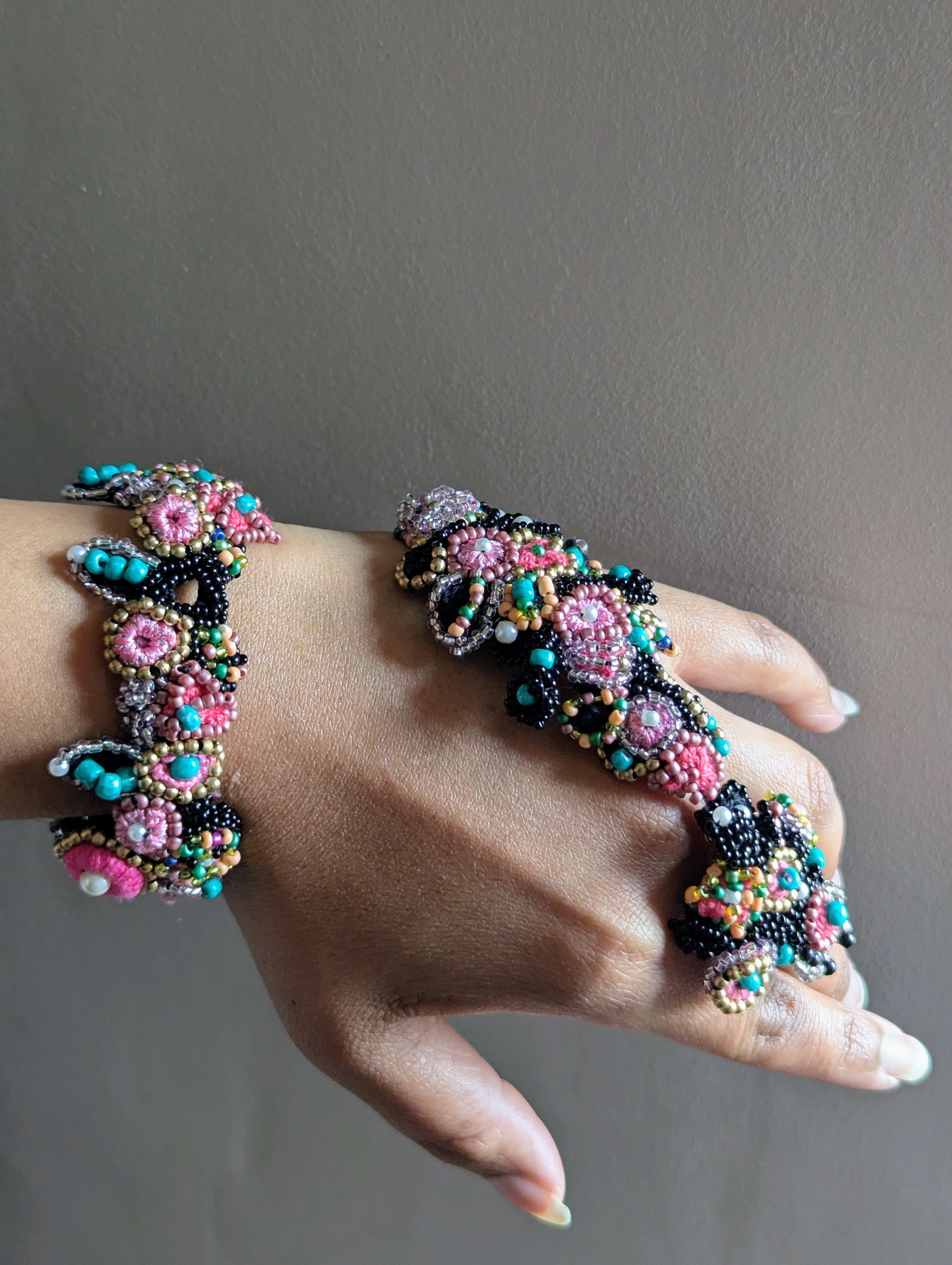 Hand modelling the Madhuri 5-in-1 Indian hand bracelet in black, pink, blue, gold and ivory pearl exclusively designed and handmade for Mayaani Jewellery UK by UK designer and artisan Megha.