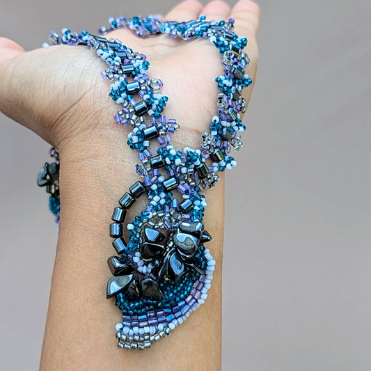 Close-up of a hand holding a vintage artisan crafted hematite beaded necklace exclusive to sustainable Indian brand Mayaani Jewellery UK.