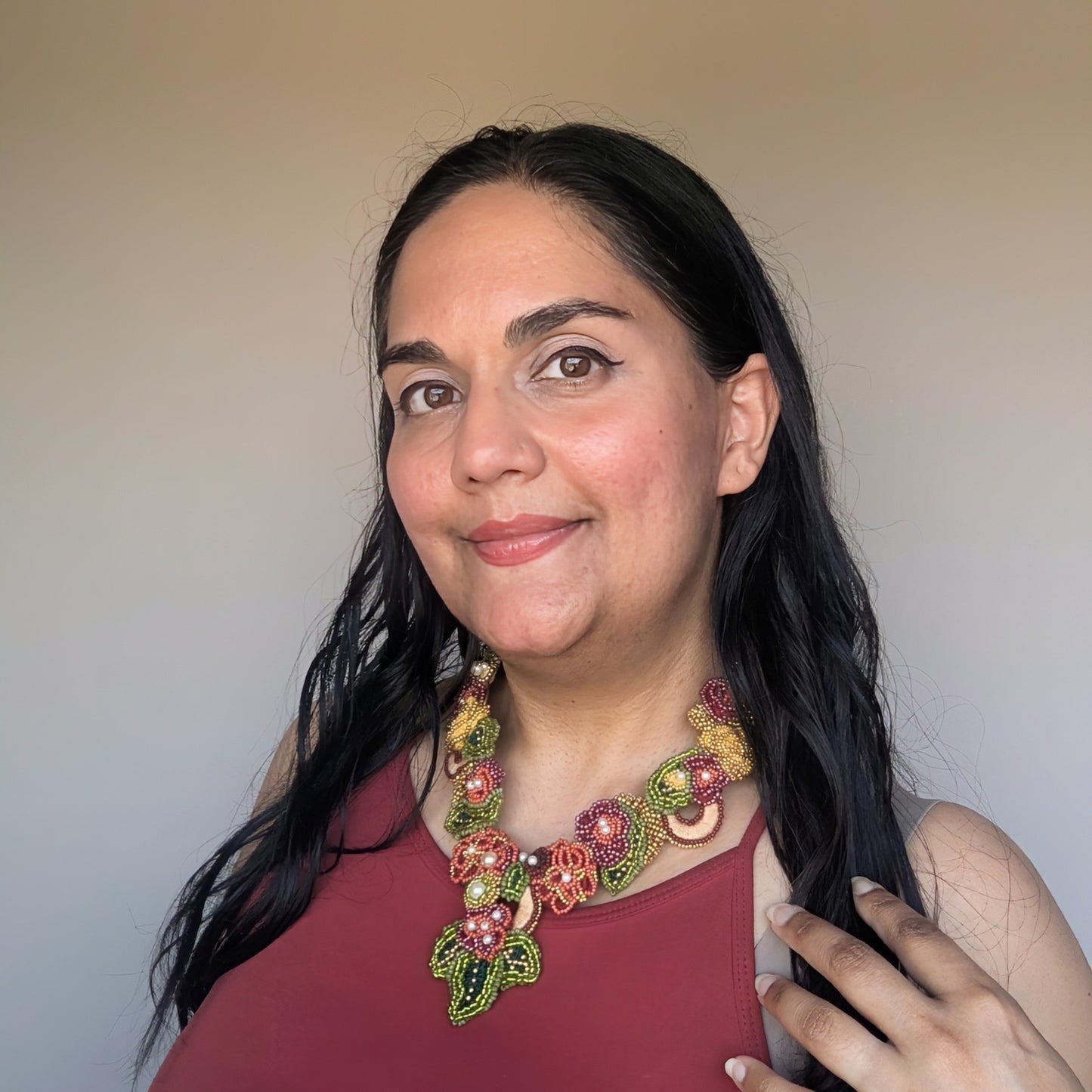 Mayaani Jewellery UK designer Megha modelling the innovative Rukmini 2-in-1 artisan handcrafted olive green, emerald green, yellow, red and gold Indian heritage inspired necklace.