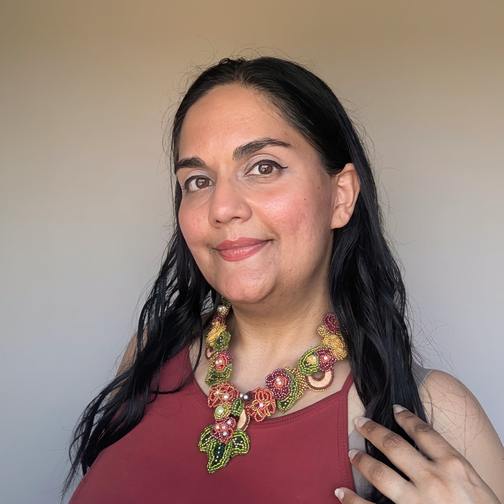 Mayaani Jewellery UK designer Megha modelling the innovative Rukmini 2-in-1 artisan handcrafted olive green, emerald green, yellow, red and gold Indian heritage inspired necklace.
