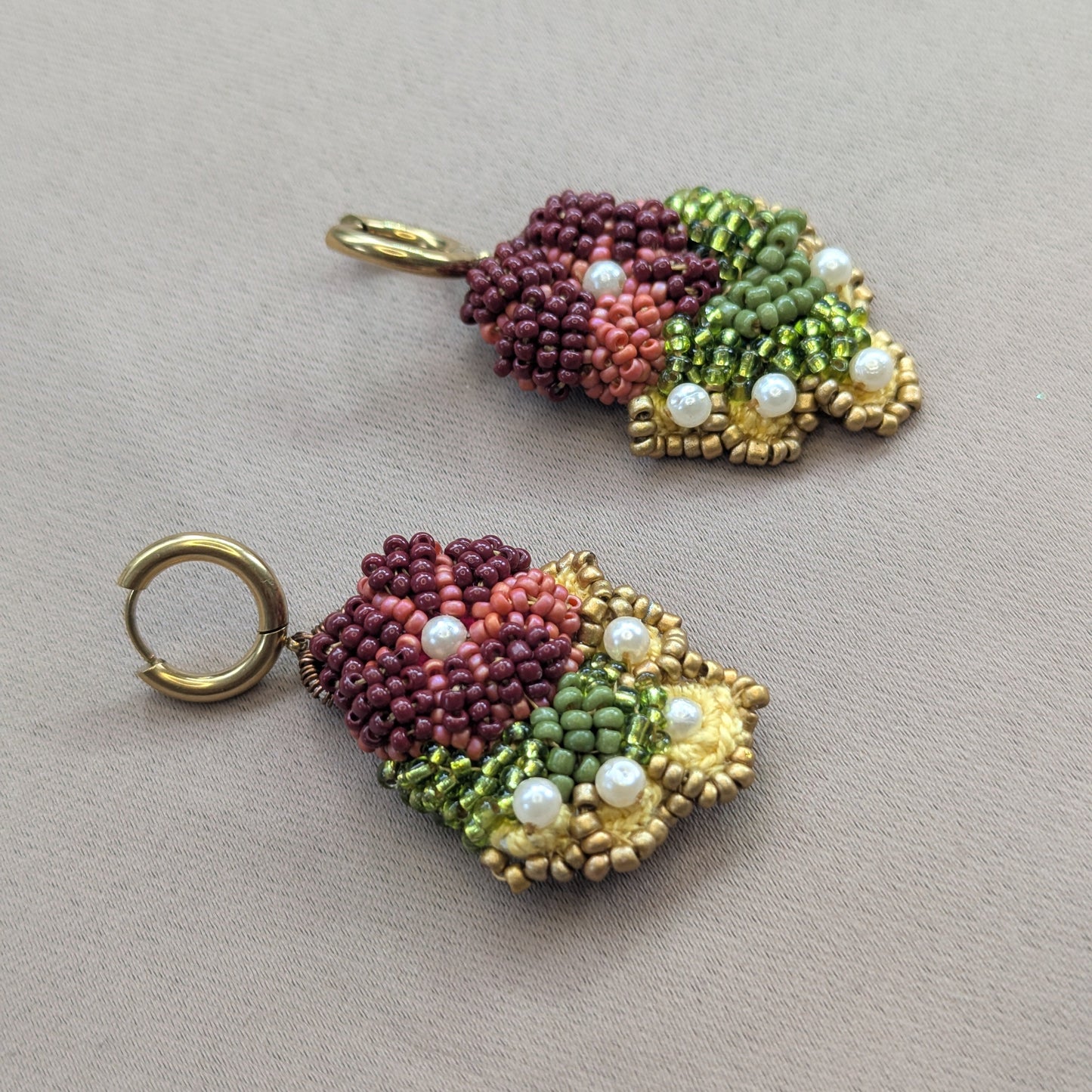 Rukmini one of a kind beaded drop earrings flat lay - handmade botanical jewellery in burgundy and gold by Mayaani Jewellery, artisan crafted in the UK.